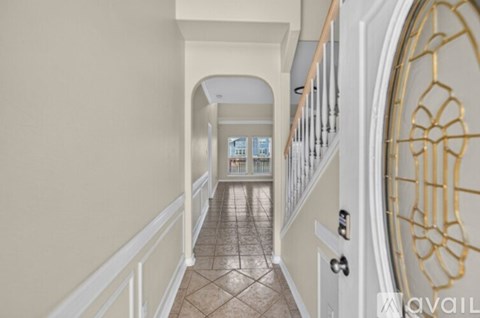 A hallway with a tiled floor and white railings.