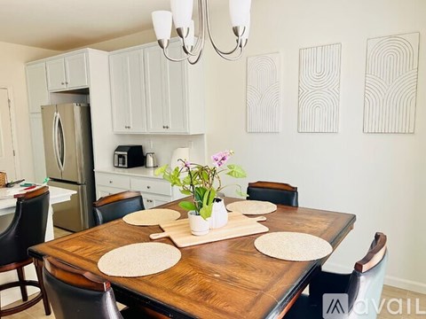 A dining room with a wooden table and chairs.