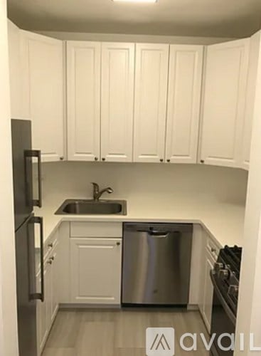 A kitchen with white cabinets and a stainless steel dishwasher.