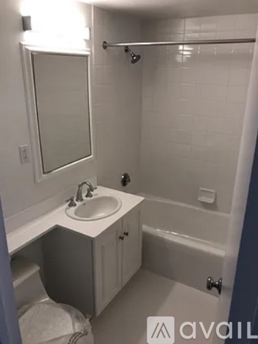 A bathroom with a sink, mirror, and bathtub.