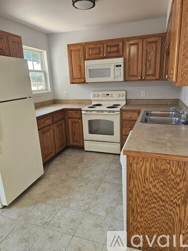 A kitchen with wooden cabinets and a white refrigerator.