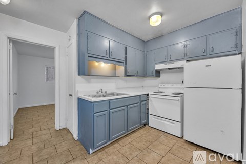 A kitchen with blue cabinets and white appliances.