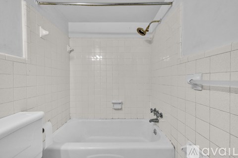A white bathroom with a tub, toilet and sink.