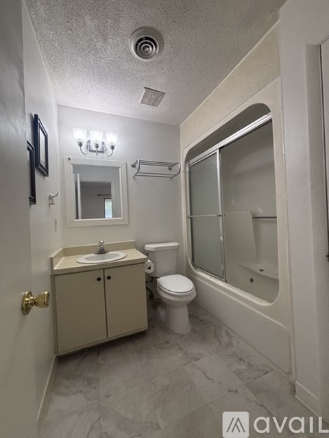 A bathroom with a sink, toilet, and bathtub.