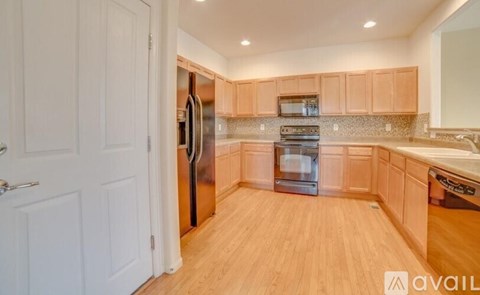 A kitchen with wooden cabinets and a white door.