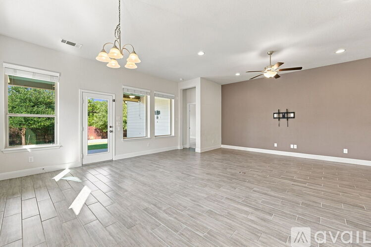 A spacious room with a ceiling fan and lighting fixtures.