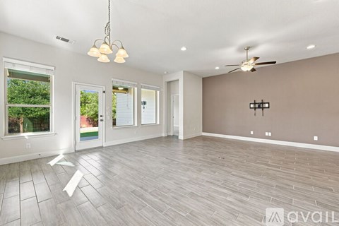 A spacious room with a ceiling fan and lighting fixtures.