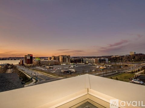 A view from a building looking out over a parking lot and other buildings.