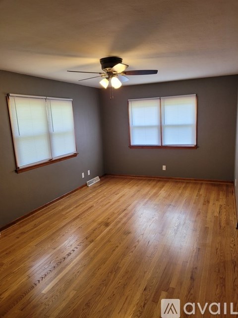 A room with wooden flooring and a ceiling fan.