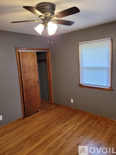 A room with a ceiling fan and a wooden door.