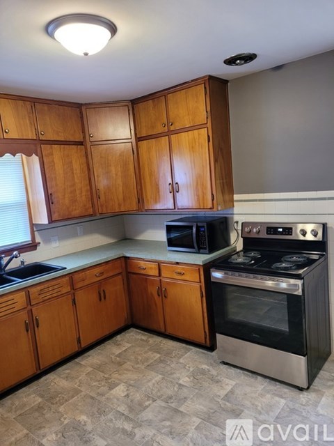 A kitchen with wooden cabinets and a stainless steel oven.