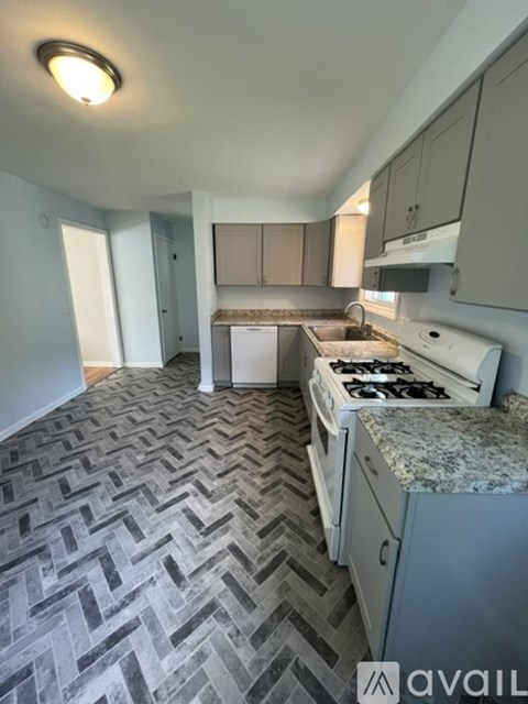 A kitchen with a patterned floor and a white stove top oven.