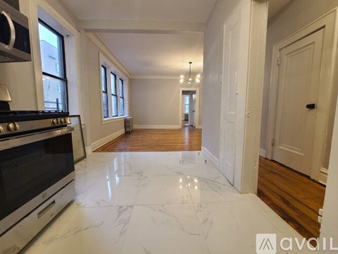 A kitchen with white marble flooring and a stove top oven.