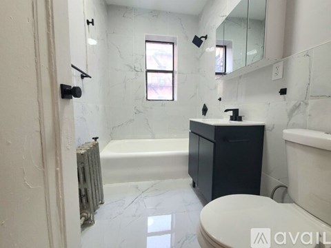 A bathroom with a toilet, sink, and bathtub.