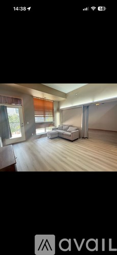 A modern living room with a white sofa and a wooden floor.