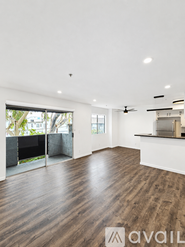 A spacious room with wooden flooring and a ceiling fan.