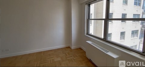 A room with a window and a radiator on the floor.