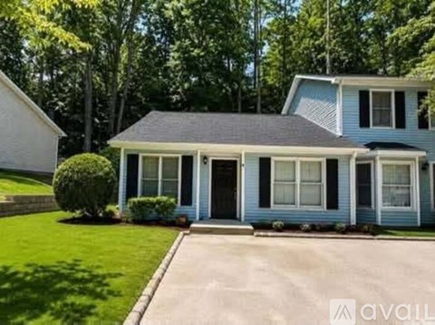 A blue house with a white garage door and a black door.