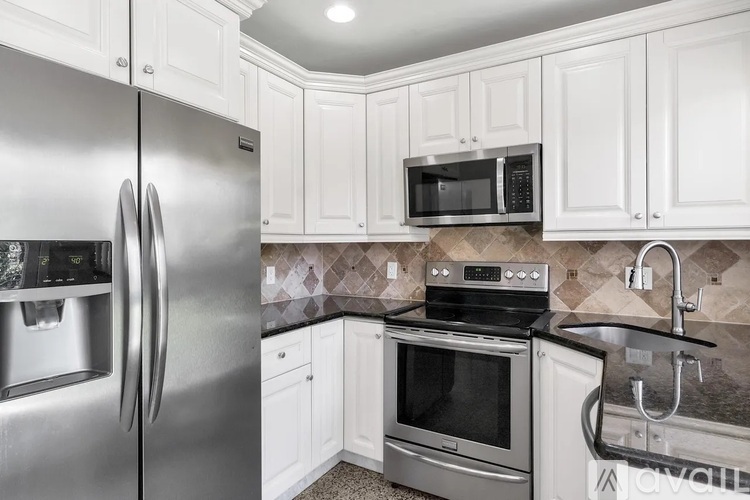 A kitchen with a stainless steel refrigerator, microwave, oven, and sink.