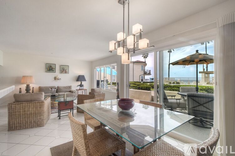 A modern dining room with a glass table and chairs.