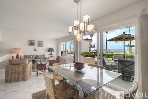 A modern dining room with a glass table and chairs.