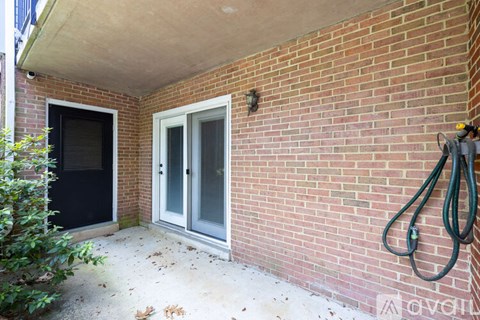 A red brick house with a grey door and a window.