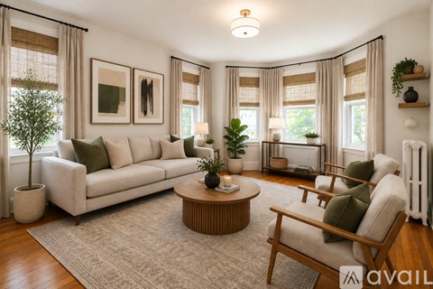 A living room with a white couch, a wooden coffee table, and a green cushion on the chair.