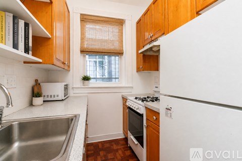 A kitchen with wooden cabinets and a white fridge.