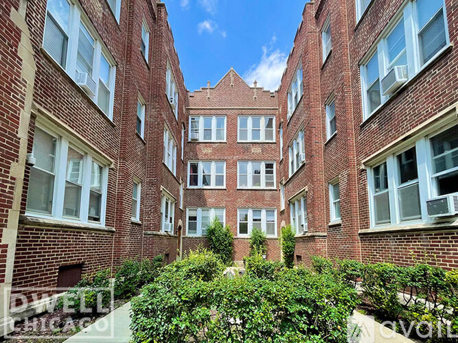 A courtyard surrounded by red brick buildings.