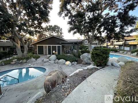 A backyard with a pool and a house in the background.