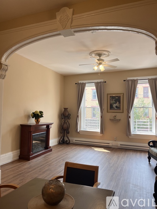 A living room with a fireplace and a dining table.