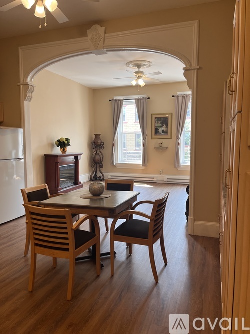 A dining room with a table set for two and a ceiling fan.