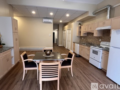 A kitchen with a table and chairs in the middle of the room.