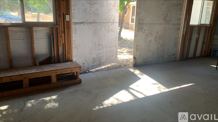 A room with a concrete wall and a wooden pallet on the floor.