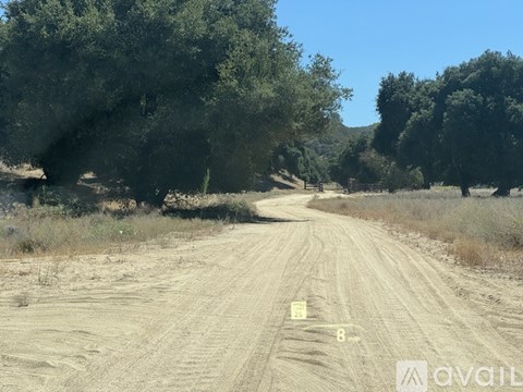 A dirt road with a yellow sign that reads "8" in the middle of it.