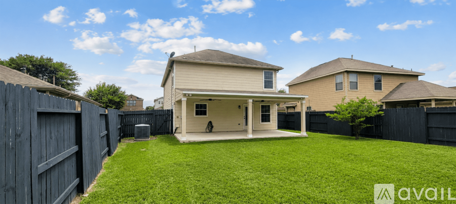 A house with a fenced backyard and a tree.