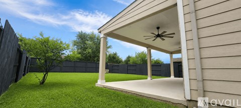 A house with a covered patio and a tree in the yard.