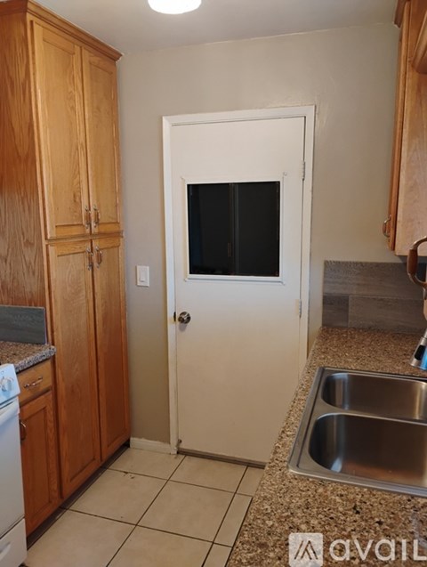 A kitchen with a sink and a door.