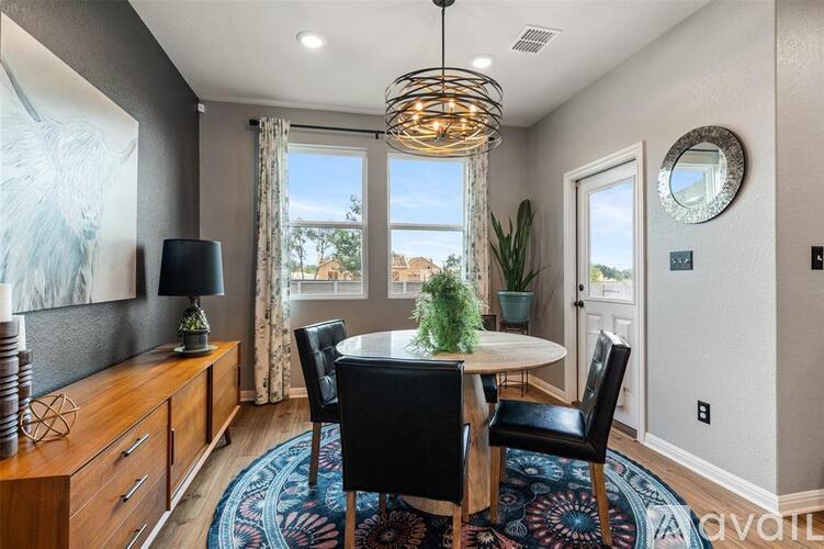 A dining room with a round table and chairs.
