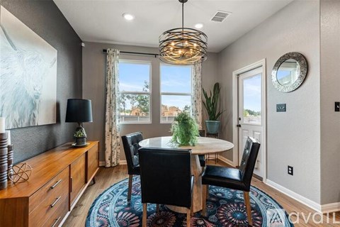 A dining room with a round table and chairs.