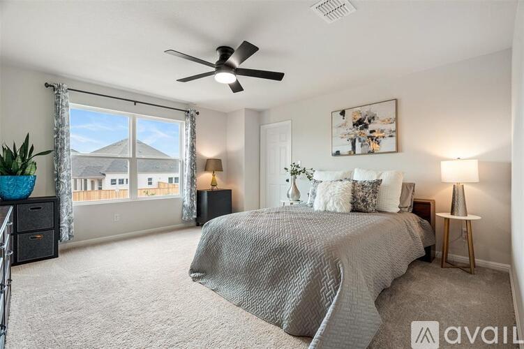 A bedroom with a large bed and a ceiling fan.