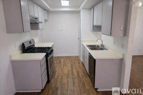 A kitchen with a stove top oven and a sink.