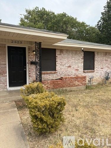A house with a black door and a number 2523 on the wall.