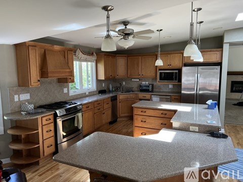 A kitchen with wooden cabinets and a granite countertop.