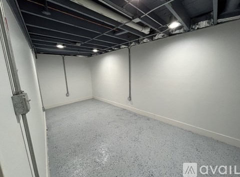 A spacious empty room with grey carpeting and white walls.