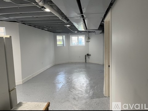 A spacious empty room with a concrete floor and white walls.