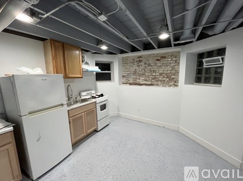 A kitchen with a refrigerator, oven, and sink.