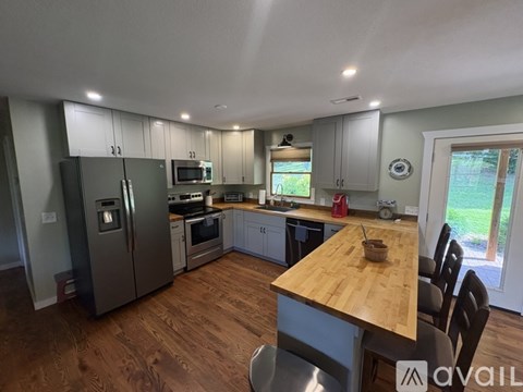 A kitchen with a wooden table and stainless steel appliances.