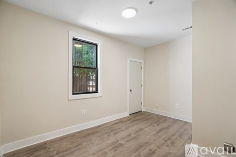 A room with a window and a door is available for rent.