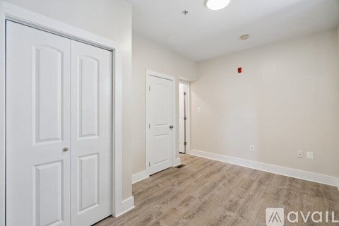 A room with two white doors and a wooden floor.